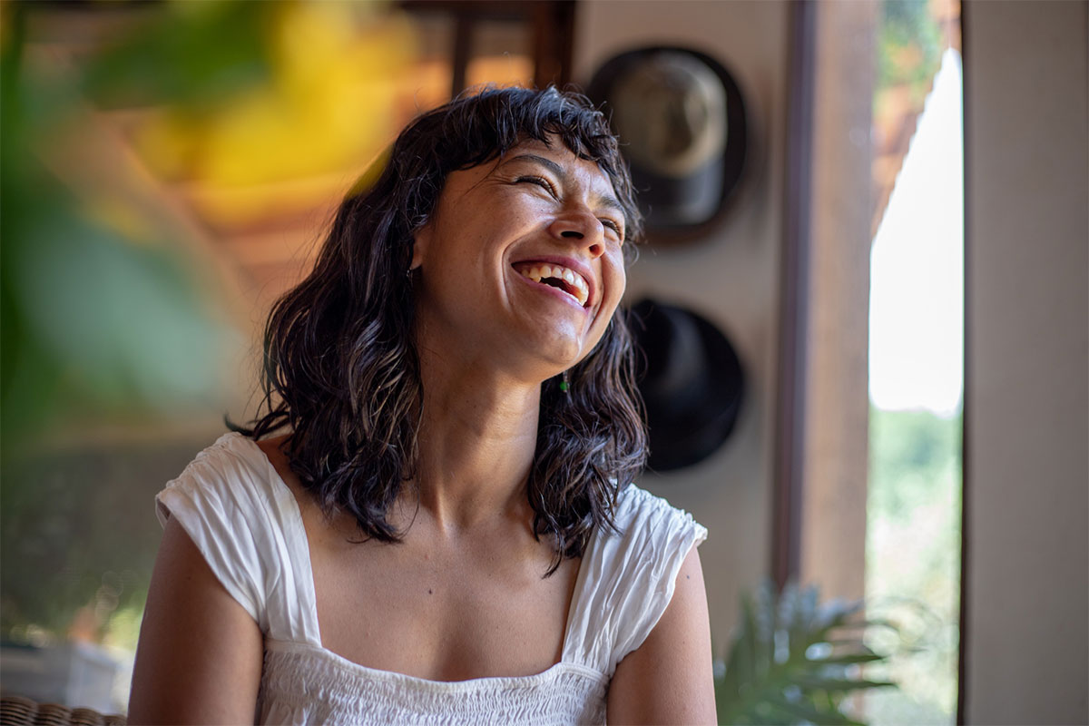 a woman smiling and tilting her head back after getting female incontinence treatment in McAllen.